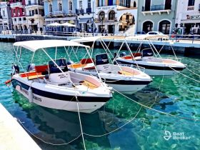 Three rental boats are docked in clear turquoise waters, showcasing a picturesque marina scene perfect for exploring coastal destinations.