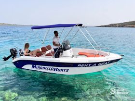 A couple enjoys a relaxing day on a rental boat in crystal-clear waters, perfect for exploring the beautiful coastline.