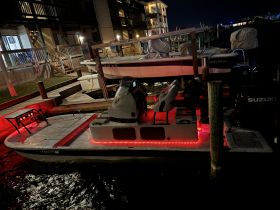 A night view of a boat docked with illuminated features, showcasing its sleek design and ambiance — perfect for evening outings on the water.