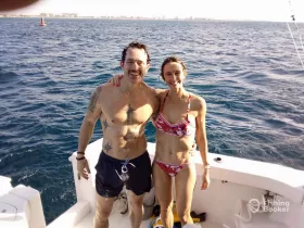 A happy couple poses on the deck of a boat, enjoying a sunny day on the ocean — perfect for memorable moments and aquatic adventures.