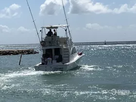 A fishing boat named 'Karma' navigates through sparkling ocean waters, showcasing a perfect day for boating adventures.
