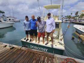 A group of friends poses on the deck of the boat 'Dorothy' at the dock, celebrating their day on the water. Perfect for fishing trips or leisure outings in the marina.