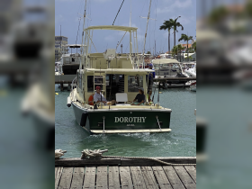 The fishing boat 'Dorothy' arrives at the marina in Aruba, showcasing a vibrant atmosphere with crew members on board, perfect for fishing adventures or island tours.