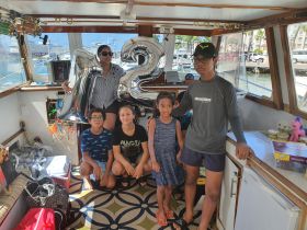 A joyful group celebrates with balloons inside a boat, capturing a memorable moment on the water — perfect for family gatherings or special occasions.