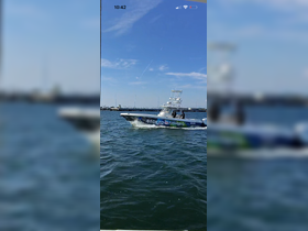 A vibrant fishing boat named 'Stoked on Fishing' cruises through the water under a clear blue sky, showcasing the excitement of a day on the water.