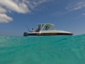 A group of explorers enjoys a day on the water aboard their fishing boat, showcasing the perfect blend of adventure and relaxation in a stunning aquatic setting.