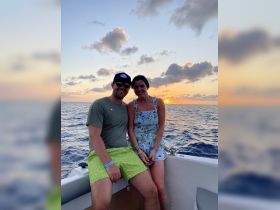A couple enjoys a romantic sunset moment aboard a boat, capturing the essence of love and adventure on the water.