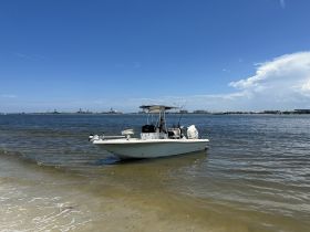 A sleek speedboat anchored in shallow waters, perfect for fishing trips or leisurely days on the water.