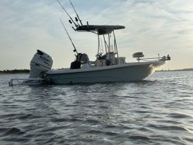 A sleek speedboat is captured in profile, showcasing its design and features while gliding through calm waters — perfect for fishing or leisure outings.