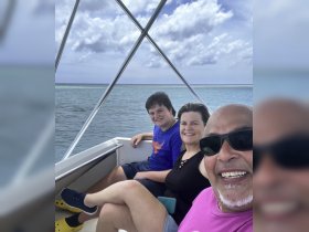 A joyful family enjoys a boat ride together, capturing smiles and memories against a beautiful ocean backdrop.