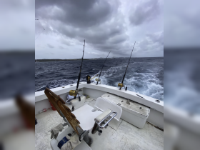 Interior view of a fishing boat's helm, featuring seating and fishing gear, ideal for anglers seeking adventure on the open water.