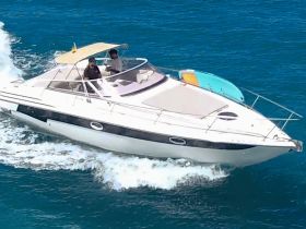 A sleek speedboat navigates through vibrant blue waters, showcasing an exciting day on the water with guests enjoying the ride.