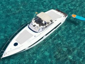 A stunning aerial view of a sleek yacht cruising through crystal-clear waters, perfect for luxury charters and island adventures.