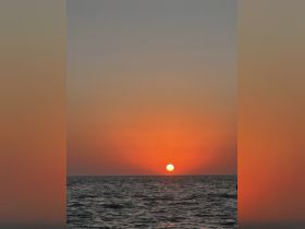 A stunning sunset over the ocean, creating a picturesque backdrop for evening boat cruises and serene moments on the water.