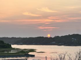 A stunning sunset over a tranquil waterway, showcasing the serene beauty of the coastline — perfect for evening boat trips or peaceful reflections.