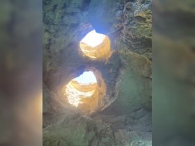 An abstract view of rock formations with light shining through openings, creating a unique natural scene.