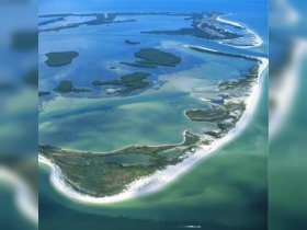 A stunning aerial view of a picturesque coastline with lush islands and clear turquoise waters, perfect for exploring by boat or enjoying a scenic cruise.