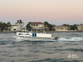 A lively boat speeds through the water, showcasing a fun day on the water with friends or family, set against a picturesque waterfront backdrop.