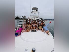 A lively group of friends celebrates on the deck of a boat, showcasing the perfect atmosphere for a fun day out on the water.
