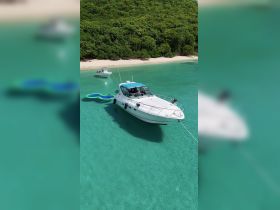 A stunning aerial view of a boat anchored in crystal-clear waters, showcasing the vibrant surroundings and perfect for a relaxing day on the water.