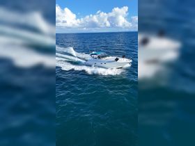 A sleek speedboat cuts through the vibrant blue waters, showcasing its design and performance while underway — perfect for thrilling adventures on the sea.
