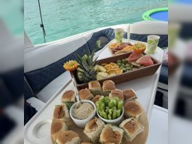 A beautifully arranged platter of snacks and fresh fruit on a boat, perfect for enjoying a day on the water with friends or family.