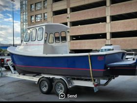 A side view of a blue boat on a trailer, showcasing its sleek design and ready for transport. Ideal for fishing or recreational outings.