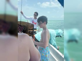 A child and crew enjoy a fishing trip on the water, showcasing the excitement of a day out at sea.