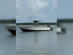 A sleek speedboat glides through calm waters, showcasing its streamlined design and fishing gear, perfect for a day out on the water.