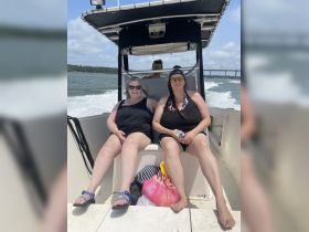 Two friends enjoy a sunny day on a boat, capturing the essence of relaxation and fun on the water.