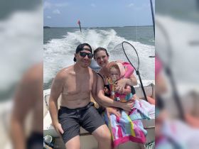 A joyful family enjoys a sunny day on the water, capturing precious moments aboard their boat. Perfect for family outings and creating lasting memories.