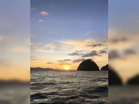 A breathtaking sunset over the coastline, with silhouetted islands creating a picturesque backdrop — perfect for romantic evenings or scenic boat trips.