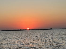 A serene sunset over the water, creating a picturesque backdrop for evening boat rides and relaxation on the water.