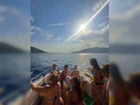 A lively group of friends enjoys cocktails on a sunny boat trip, capturing the essence of a perfect day on the water.