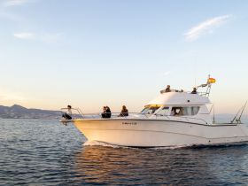 A group enjoys a scenic sunset cruise aboard a sleek boat, capturing the essence of relaxation and adventure on the water.
