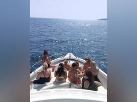 A lively group of women enjoys a sunny day on a boat, celebrating with drinks and laughter — perfect for summer outings and memorable gatherings.