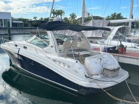 A sleek yacht named 'Sun Dancer' docked at a marina, showcasing its elegant design and tranquil surroundings.