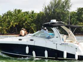 A couple enjoys a romantic moment on the bow of a boat, surrounded by lush tropical scenery — perfect for a day of relaxation on the water.