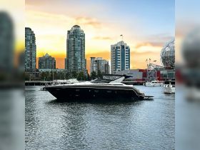 A stunning yacht docked in the harbor against a backdrop of modern skyscrapers and a vibrant sunset, perfect for luxury boating experiences.