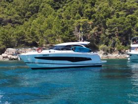 A sleek yacht anchored in clear turquoise waters, surrounded by lush greenery — perfect for summer getaways and luxury charters.