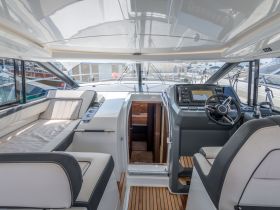 The interior of a modern yacht showcasing a stylish helm and comfortable seating area, perfect for navigating the open waters in luxury.