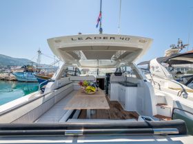 Interior view of a luxurious yacht featuring a spacious dining area with seating and a beautiful table, perfect for enjoying meals on the water.