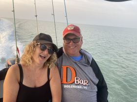A cheerful couple enjoys a boat ride, capturing a moment of joy on the water — perfect for romantic getaways or fun outings.