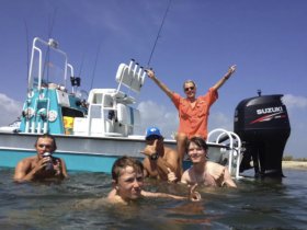 A lively group enjoys a fun day of fishing and swimming near their boat, capturing the essence of adventure on the water.