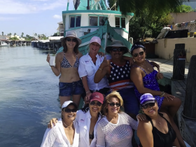 A joyful group of friends poses together on a boat, capturing the essence of fun and camaraderie during their boating adventure.