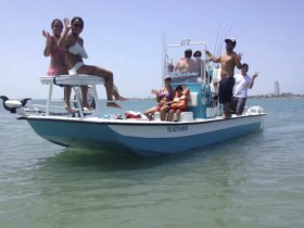 A lively group waves from their boat, enjoying a fun day on the water — perfect for family outings or group adventures.