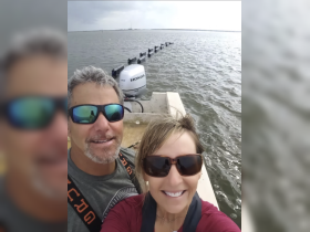 A cheerful couple takes a selfie on their boat, enjoying a day out on the water — perfect for capturing memorable moments during their boating adventures.