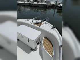 A detailed view of the interior of a boat showcasing the helm area and seating, perfect for enjoying a day on the water.