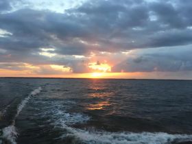 A stunning sunset over the water, showcasing vibrant colors and serene scenery — perfect for capturing the beauty of evening boat trips.