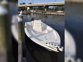 A sleek center console boat docked at the marina, showcasing its clean lines and functional design, perfect for fishing or leisurely outings on the water.